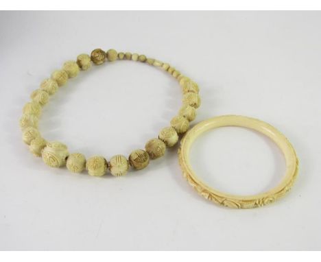 A bone necklace and bangle. 
