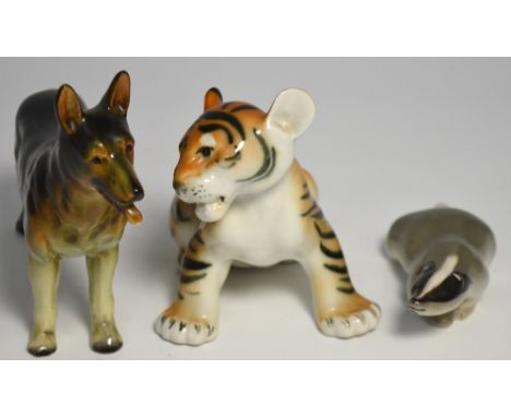 Two Russian figurines one modelled as a tiger, the other as a badger both with printed marks to the base and USSR and a ceram