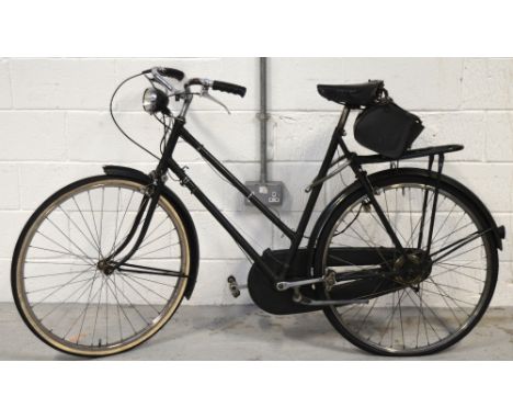 A vintage lady's dark green Raleigh bicycle with front light and rear leather saddle bag, with Sturmy-Archer four speed hub g