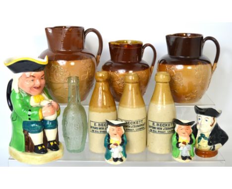 A set of three Doulton Lambeth salt glazed graduating hunting jugs, three toby jugs and three ceramic lemonade bottles for E 