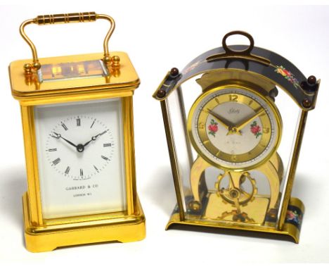 A reproduction brass carriage clock the dial set with Roman numerals and inscribed Garrard & Co, London W1, height 12cm and a