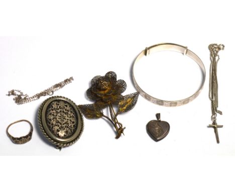 A hallmarked silver bangle, silver heart shaped locket, a white metal ring, a white metal filigree brooch in the form of a ro