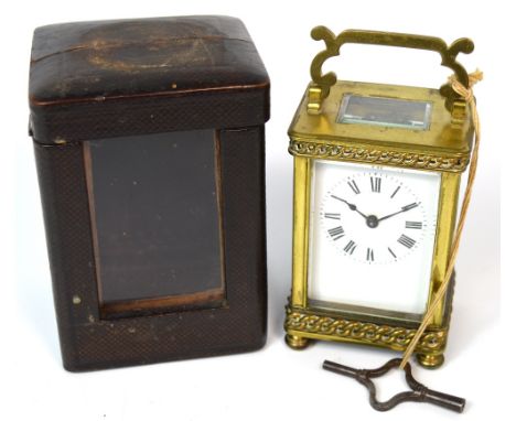 A 19th century French carriage clock with white enamel dial set with Roman numerals, raised on small bun feet with leather an