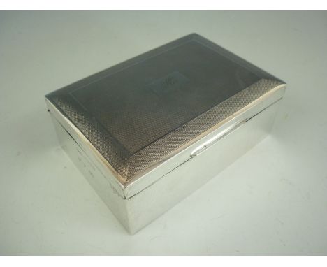 An Elizabeth II silver table cigarette box, with engine turned decoration surrounding a central monogram, each end engraved w