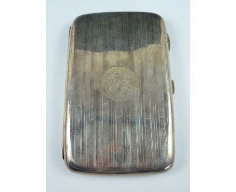 A George V silver cigarette case, of rounded rectangular form, having engine turned banded decoration surrounding a central m