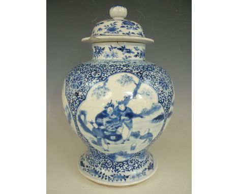 A large Quing Chinese porcelain covered vase, of inverted baluster form with domed cover, decorated with vignettes depicting 