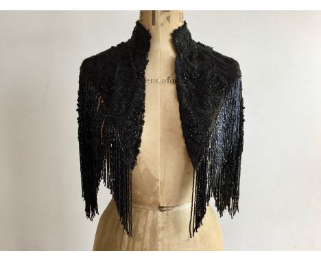 A late Victorian jet beaded evening mantle, with mandarin collar, decorated with a scrolling foliate design over mesh incorpo