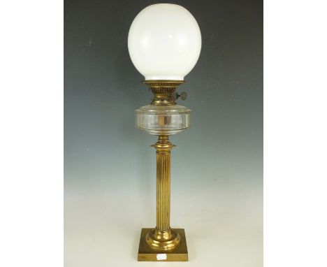 A 19th Century lacquered brass columnar oil lamp, with clear glass reservoir and milk glass shade, 66 cm 