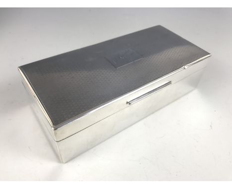 A George V silver table cigarette box, of rectangular form, with engine turned lid  centred with a cartouche bearing the engr