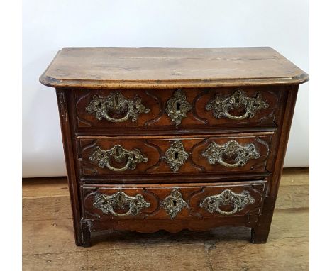 A 19th century French miniature/table top commode, having three long drawers, on square legs,  54 cm wide 