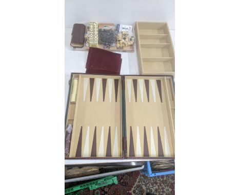 A Backgammon and games set housed in a case with a set of dominoes, playing cards, a chess board and pieces and other items L