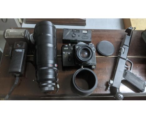 Photographic equipment to include a Zenith 12S camera, a Hanimex Prosso flash, a Tair 3S lens and other items housed in a car