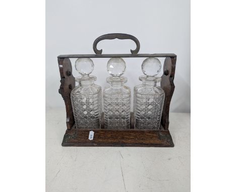 An Edwardian oak three-section Tantalus stamped 'Betjemanns' Location:If there is no condition report shown, please request