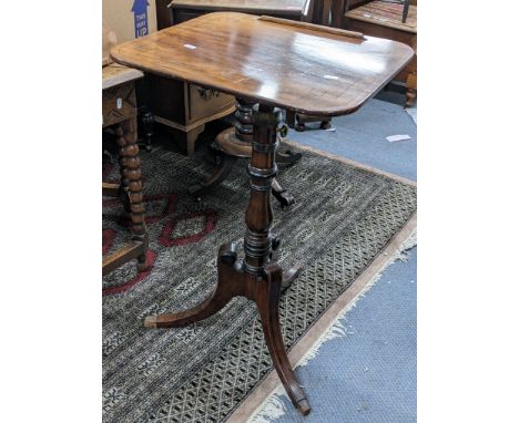 An early 19th century string inlaid mahogany pedestal reading table with a ratchet adjustable top and height adjustable colum