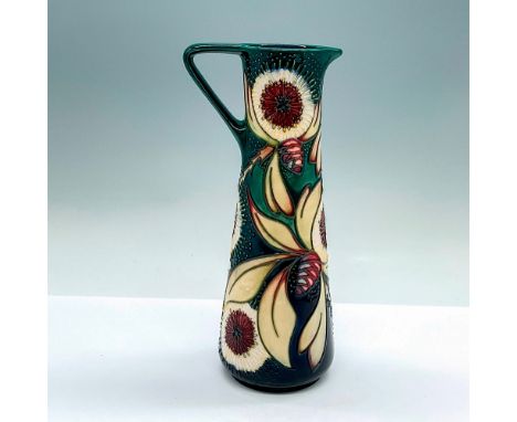 A green glazed pitcher with a dandelion and acorn motif. Detailed tube lining. Moorcroft marking on the base. Artists' markin
