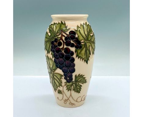 A cream-colored ground vase in a grapevine motif and detailed tube lining. Moorcroft and Moorcroft Collectors Club stamped on