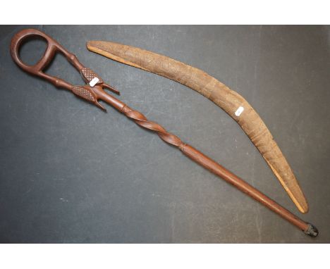 A vintage wooden Boomerang together with a carved wooden walking stick. 