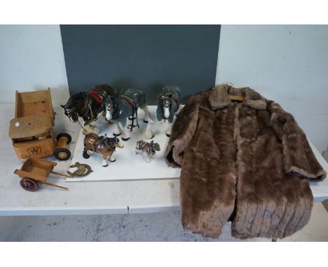A collection of vintage ceramic horses together with a wooden truck and a fur coat. 
