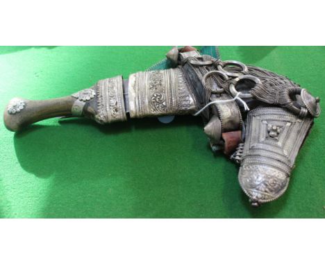 An Omani silver coloured metal mounted dagger (Khanjar) with sheath