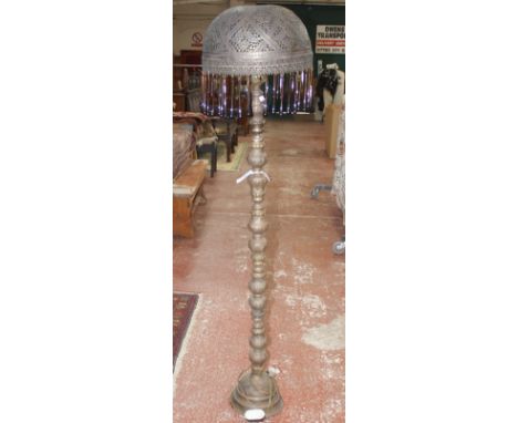 A North African brass standard lamp, 20th century, with domed shade and drop pendants, on knopped stem 167cm high (sold as pa