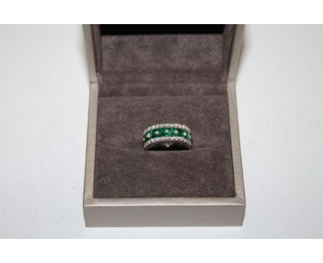 A WHITE GOLD EMERALD AND DIAMOND RING, set with an estimated 1.20 carats of emeralds and twenty brilliant cut diamonds totall