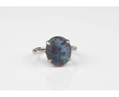 An 18ct white gold and opal triplet ring - stamped '18CT', the 11.5 x 10mm. oval cabochon opal triplet in a four-claw setting