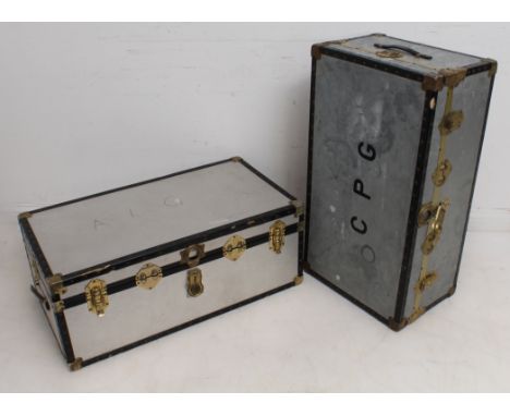 Two vintage brass-bound metal streamer or travel trunks - one with galvanised metal outer, the other with textured aluminium.