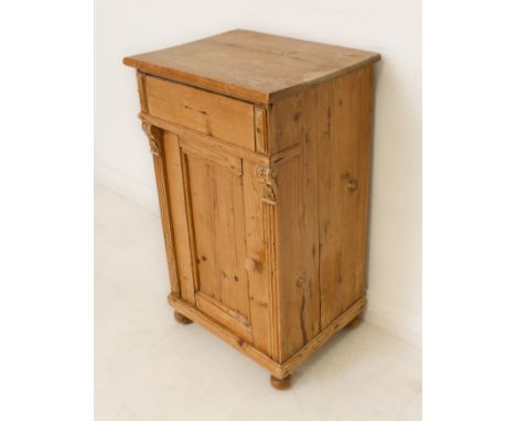 A Victorian pine bedside cabinet - single frieze drawer (lacks handle), on shell carved brackets over a panelled door enclosi