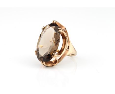 A vintage 9ct gold and smoky quartz ring - hallmarked Birmingham 1974, the large 2.1 x 1.25cm. oval cut smoky quartz in a six