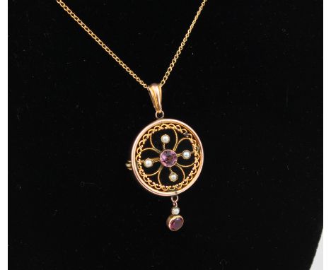 An early 20th century 9ct rose gold, amethyst and seed pearl pendant brooch - target shaped with a quatrefoil set with a cent