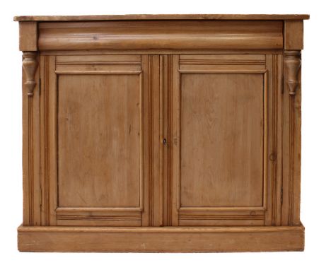 A Victorian waxed pine cupboard bookcase - the flared, moulded top over a pair of arched glazed doors enclosing three adjusta