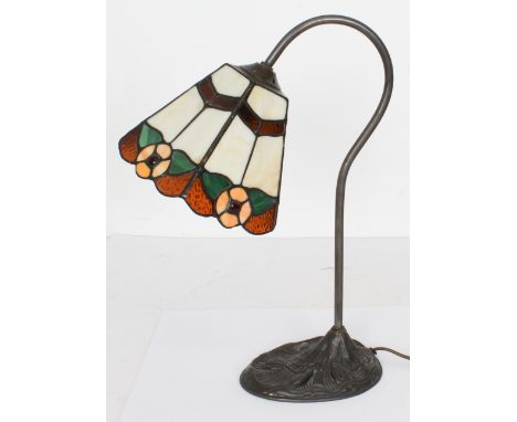 A Tiffany style stained glass reading or desk lamp - modern, with flared, floral decorated stained glass shade on a scrolled 