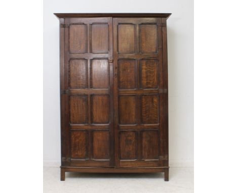 A panelled oak single wardrobe in the 18th century style - early 20th century, the flared, ogee cornice over a pair of eight 