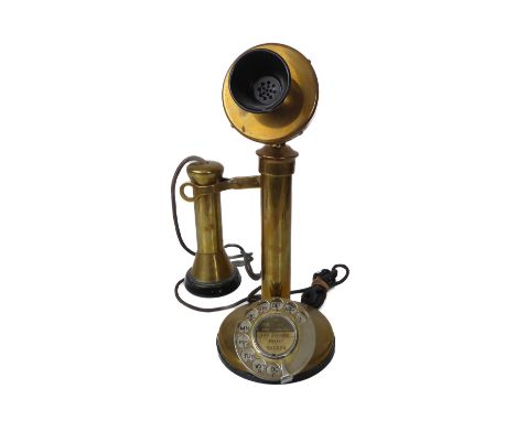 A vintage brass and black bakelite candlestick telephone - with plated brass dial, 31.5cm. high.