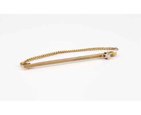 A 9ct gold bar brooch or tie pin - marked '9CT', the plain bar set with a single old cut diamond to one end, 4.7cm. long.