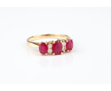 A 14ct gold, ruby and diamond seven stone ring - stamped '14K 585', the three oval cut rubies divided by pairs of brilliant c