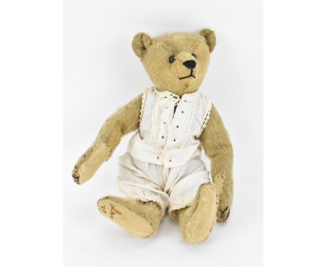 An early 20th century humpback Steiff bear, circa 1910, with pointed nose, shoe button eyes, straw filled, with padded paws a