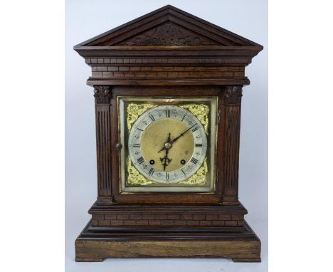 A late 19th century oak mantle clock, the case of architectural design having composite Greek style columns flanking the 7" d