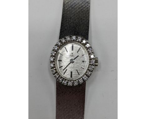 A Ebel manual wind ladies 18ct white gold and diamond wristwatch, having a textured silvered dial with baton markers, the mov