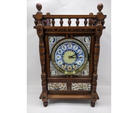 A late 19th century Aesthetic style walnut and blue and gilt enamelled ceramic tile mounted mantel clock, the rectangular arc