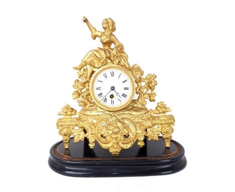 A late 19th century French gilt metal mantle clock, the case having a female seated on the drum head clock and having a flora