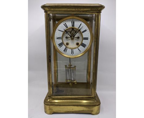 A late 19th century large French gilt brass mantle clock having a white enamel chapter ring with Roman numerals and visible B