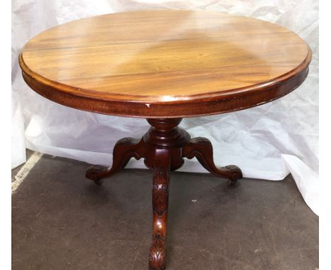 A Victorian mahogany breakfast table, circa 1860, the circular tilt-top, on a turned pillar and foliate carved tripod base an