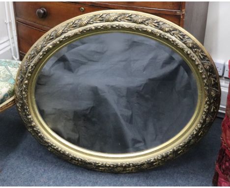 A Victorian oval bevel edge wall mirror, the gilt gesso frame decorated with ferns and ribbon tied fruiting branches, 103 x 8