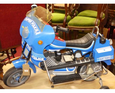 A child's model Super Police motorbike, battery powered, with stabiliser framework
