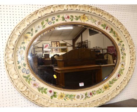 A decorative floral and cream painted oval bevelled wall mirror, having moulded repeating leaf raised decorated surround, 78 