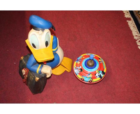 A resin figure of Donald Duck, together with a tinplate Triang Chad Valley merry-go-round and a Abbatt wooden educational pla