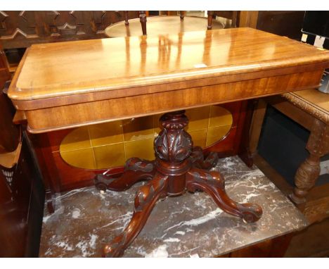 A mid-Victorian mahogany round cornered fold-over card table, having a circular baize lined interior, swivel action, and rais