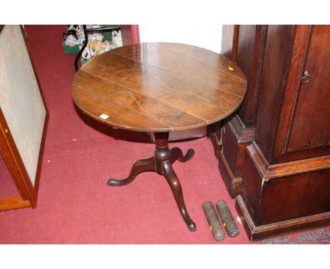 An early 19th century provincial oak circular tilt-top pedestal tripod table, dia. 76cm