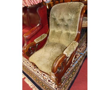 A mid-Victorian mahogany showframe open armchair, having green floral fabric button upholstery, scroll arms on turned foreleg